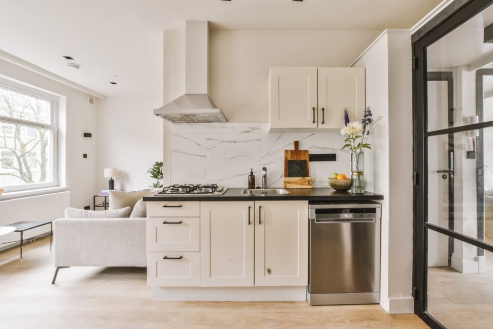 A kitchen with white cabinets and a stainless steel sink