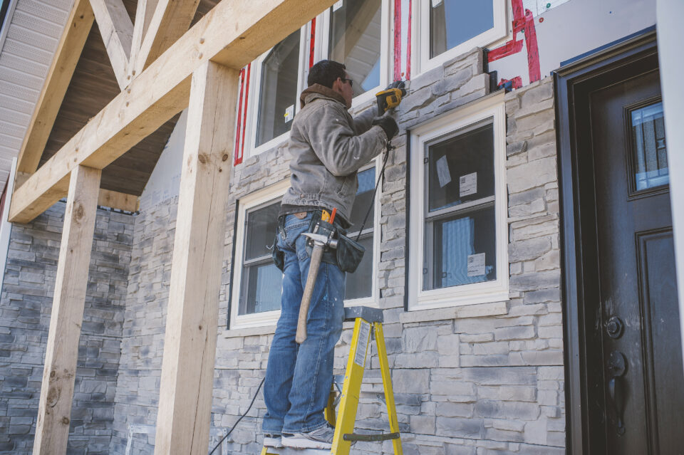 Builder tiling facade of house